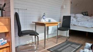 GützkowにあるTiny Haus 1のデスク、椅子2脚、ベッド1台が備わる客室です。