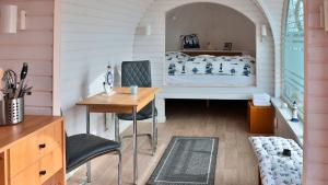Cette chambre comprend un lit, un bureau et une table. dans l'établissement Tiny Haus 1, à Gützkow