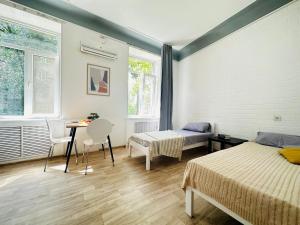 1 dormitorio con 2 camas, mesa y sillas en Гостевой дом на Культуры en Járkov