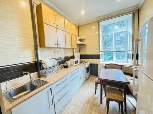 a kitchen with a sink and a table in it at Гостевой дом на Культуры in Kharkiv