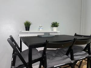 una mesa de comedor negra con 2 sillas en 3 Bedrooms spacious house in Calcot , Reading, en Tilehurst