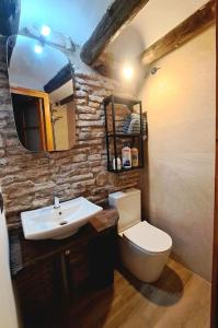 a bathroom with a sink and a toilet and a mirror at Ca la Maria in Lilla