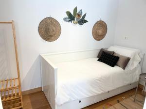 um quarto com uma cama branca e uma borboleta na parede em BAKEA Apto con jardín privado em Bakio