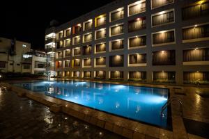 a hotel with a swimming pool at night at Hotel Atithi, Aurangabad in Aurangabad