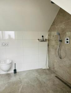 een badkamer met een douche en een toilet bij Duinzand in Noordwijk aan Zee