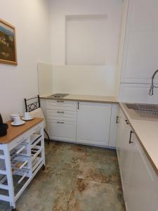 a kitchen with white cabinets and a wooden table at Charmantes Haus mit Terrasse und großem Garten in Langenzersdorf