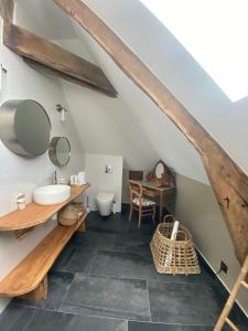 uma casa de banho com um lavatório e um WC em Le Clos Luly em Neulliac