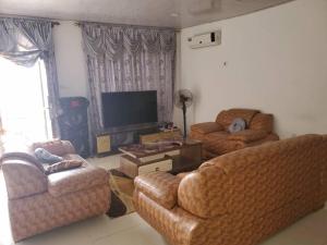 ein Wohnzimmer mit 2 Sofas und einem Flachbild-TV in der Unterkunft Savagem Furnished Apartment in Freetown