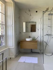 a bathroom with a sink and a mirror at Beau château dans le Cantal au coeur du Pays Vert in Naucelles +17 photos