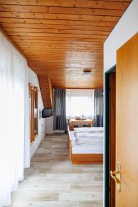 una camera con letto e soffitto in legno di Drexl Gasthof Shiro a Schondorf am Ammersee