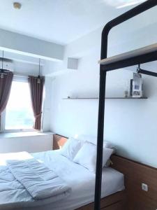 a bedroom with a bunk bed and a window at Apartemen Comfy Urbano Bekasi in Bulanbulan