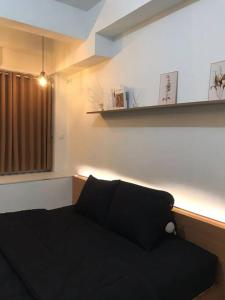 a black couch in a room with a window at Apartemen Comfy Urbano Bekasi in Bulanbulan