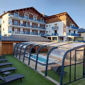 a view of a hotel with a swimming pool and chairs at Hôtel L'Oustalet in Font Romeu Odeillo Via