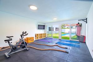 uma sala de fitness com um ginásio com uma passadeira e uma passadeira em Portugal Active Cabedelo Beach Lodge - Heated Pool em Viana do Castelo