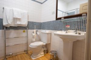 a bathroom with a toilet and a sink at Millers Hotel by Greene King Inns in Sibson +35 photos