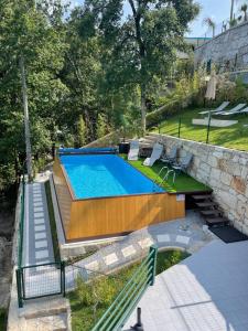a swimming pool in a yard next to a stone wall at Estrela do Geres in Geres