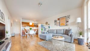 a living room with a couch and a table at Apartamenty Sun & Snow Bałtyk Park Grzybowo in Grzybowo