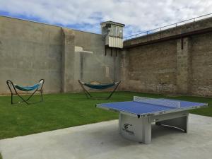 a ping pong table and two chairs in a yard at Fremantle Prison YHA in Fremantle
