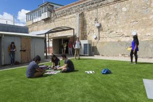 people sitting in a grassy area next to a building at Fremantle Prison YHA in Fremantle