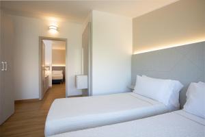 a hotel room with two beds and a mirror at Lu' Hotel Porto Pino in SantʼAnna Arresi