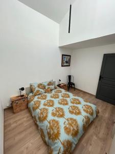1 dormitorio con 1 cama con colcha de flores en Villa proche centre Montpellier en Montpellier