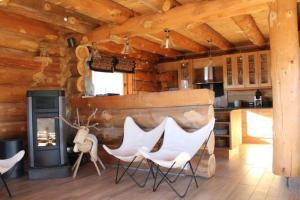 a log cabin kitchen with white chairs and a fireplace at Oxygene in Font-Romeu-Odeillo-Via