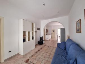 a living room with a blue couch and a kitchen at A 2 passi dal blu in Roseto degli Abruzzi
