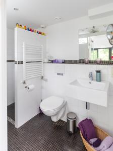 bagno bianco con servizi igienici e lavandino di B&B van Dinter a Valkenswaard