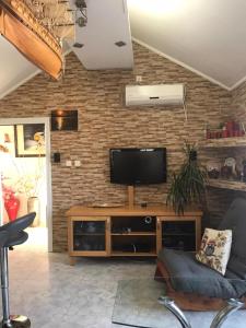 a living room with a television on a brick wall at Givat Zeev - between Jerusalem and Tel Aviv, 25 minutes from the airport in Giv'at Ze'ev