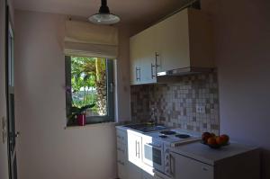 a kitchen with a sink and a stove and a window at Casa Muraglia Studio/Studio Under Castle in Travliáta