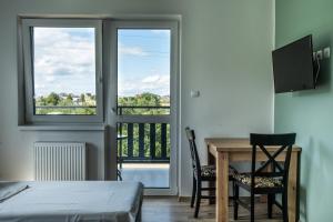 a bedroom with a table and chairs and a balcony at Zajazd Tadeo in Pietrzykowice