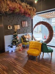 a living room with a christmas tree and a yellow chair at Slow Wow Hot Spring Hotel in Jiaoxi