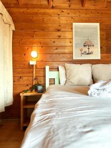 a bedroom with a bed and a table with a lamp at Eden Ramot Chalets in Moshav Ramot