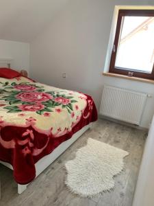 sypialnia z łóżkiem, dywanem i oknem w obiekcie Apartmán u Českého Ráje w mieście Kněžmost