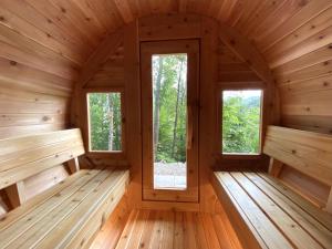 une pièce vide avec 2 fenêtres dans une cabane en bois dans l'établissement Le Harfång - Vue spectaculaire sur le Mont Edouard, à LʼAnse-Saint-Jean