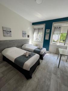two beds in a room with two windows at Cit' Hôtel Agena in Brest +46 photos