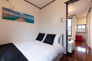 a bedroom with a white bed with black pillows at City center Shibuya -都心縁渋谷- in Tokyo +26 photos