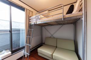 a bunk bed in a room with a couch and a window at City center Shibuya -都心縁渋谷- in Tokyo