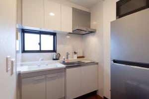 a small white kitchen with a sink and a window at City center Shibuya -都心縁渋谷- in Tokyo