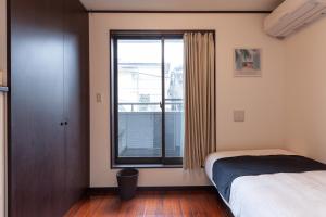 a bedroom with a bed and a window at City center Shibuya -都心縁渋谷- in Tokyo