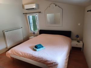 a bedroom with a white bed with a blue box on it at Maison de village en pierre in Mollans-sur-Ouvèze