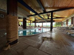 a large swimming pool with chairs and a person in a pink raft at Complex Padina Ursului Fundata in Fundata