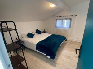 - une chambre avec un lit doté d'une couverture bleue et d'une échelle dans l'établissement Jolie maison proche de Toulouse, à Lherm