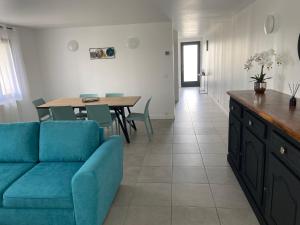 a living room with a blue couch and a table at Maison de vacances avec piscine et jardin privé in Lherm