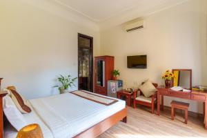 a bedroom with a bed and a desk and a computer at Thien Tan Villa with Private Pool in Hoi An