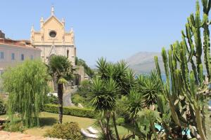 Blick auf ein Gebäude mit Palmen und einer Kirche in der Unterkunft Clori Gaeta in Gaeta