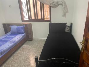1 Schlafzimmer mit 2 Betten und einem Fenster in der Unterkunft Kenitra شقة in Kenitra