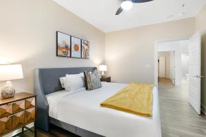 a bedroom with a large white bed and a lamp at Luxury 4B Condo Newly Renovated Steps to French Quarter in New Orleans