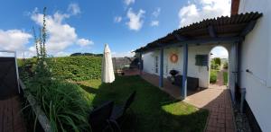 a yard with an umbrella and a building at Fewo Steuerbord in Rambin