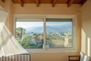 a window in a bedroom with a view of a town at Villa Oasis Kato Alepochori in Kato Alepochori